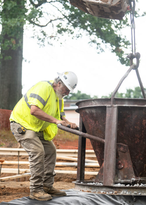 A Pace contractor installs a large construction object into the ground on a construction site
