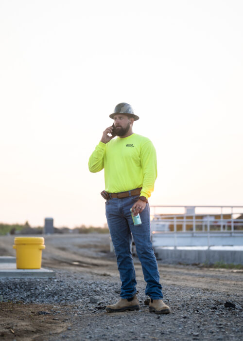 A Pace contractor stands in a road in Kentuckiana in a hard hat and vest