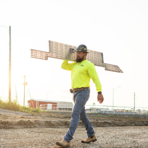 A Pace construction worker carries construction materials on a job site in Kentuckiana