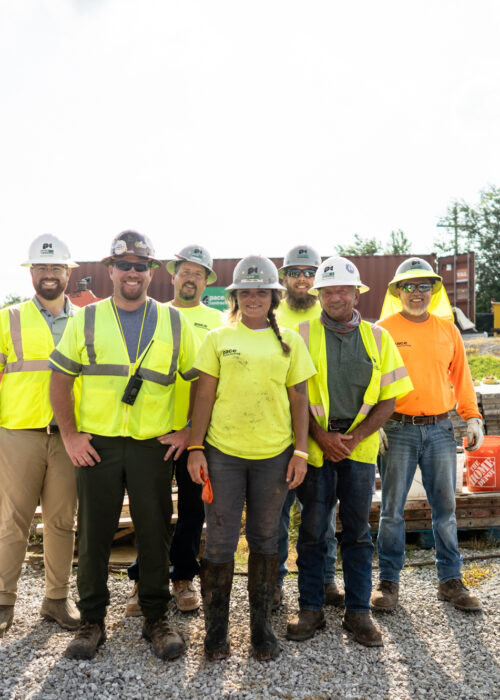Pace employees pose together with hard hats and vests on in Kentuckiana